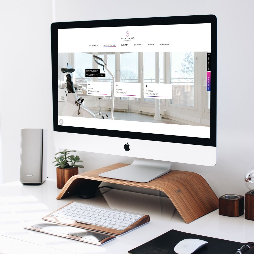 Moderner Arbeitsplatz mit PC, zeigt die Webseite einer Herzpraxis, Fokus auf klare Gestaltung und medizinische Informationen.